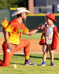 Garrett DeClure with the The Firefighters talking to a young fan during a game this summer.