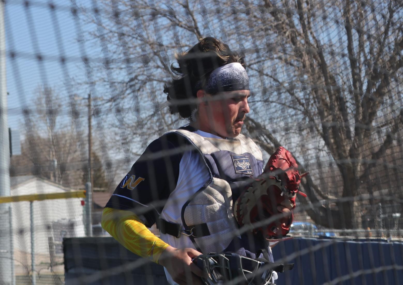 Jase Satterfield looks at the ball in his golf after catching a foul ball by the backstop for an out. WNCC won both games Friday against Luna.