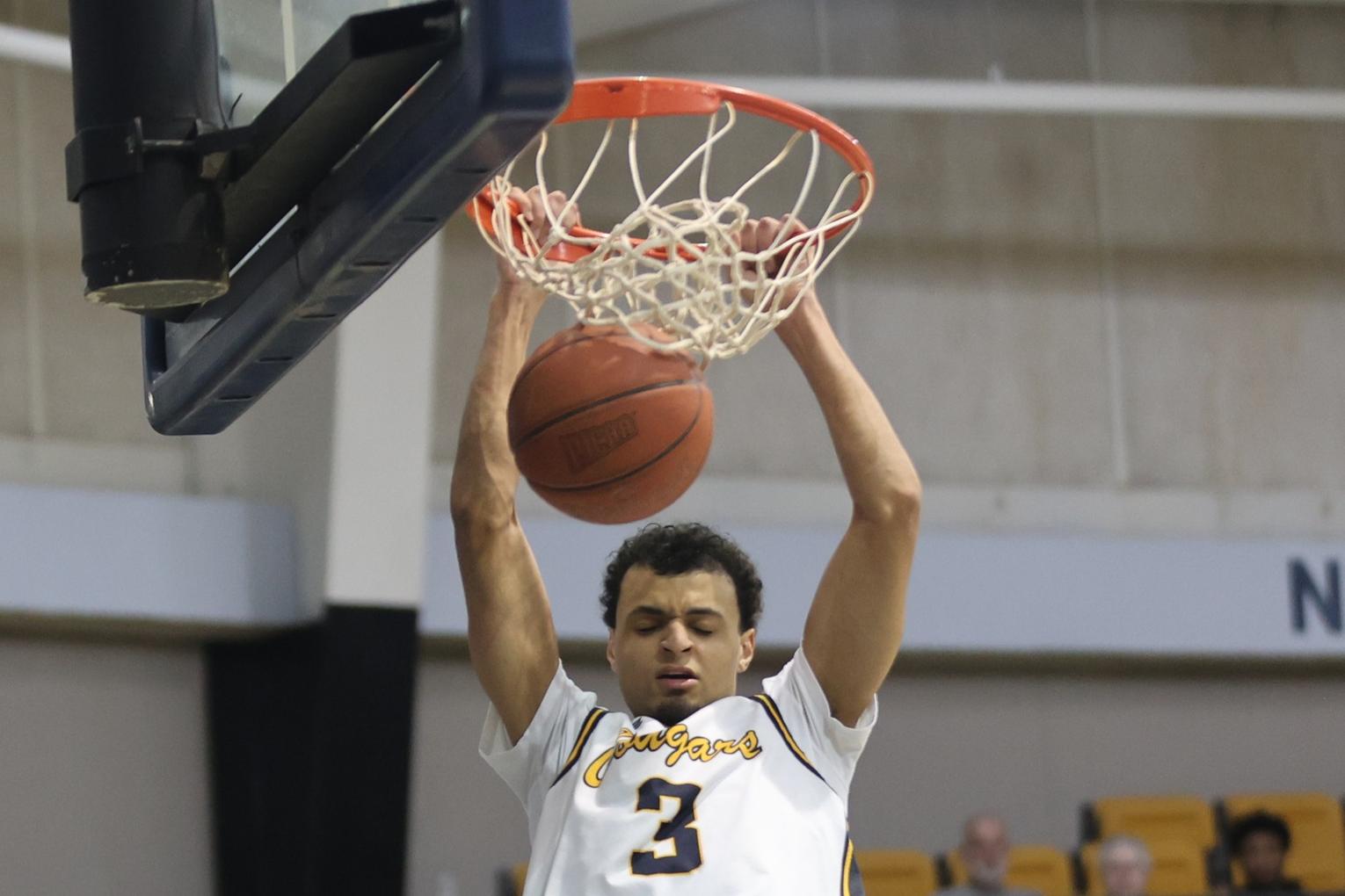 Kellon Harris dunks home two of his 24 points as the Cougars downed McCook 107-73 in a first-round playoff game at Cougar Palace on Saturday.