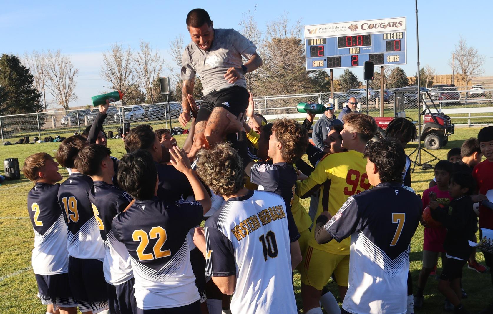 Eseah Ingram is lifted into the air by the men's soccer team after they won the Region IX tourney in November.