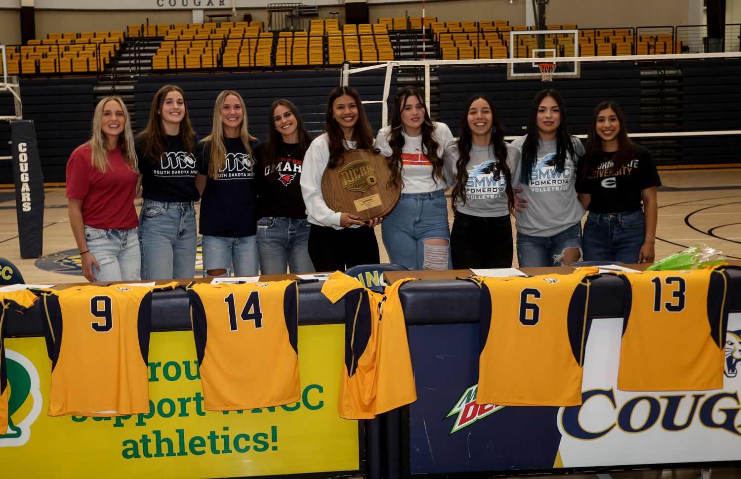 All nine WNCC volleyball players with the shirts that they are wearing where they will be attending.